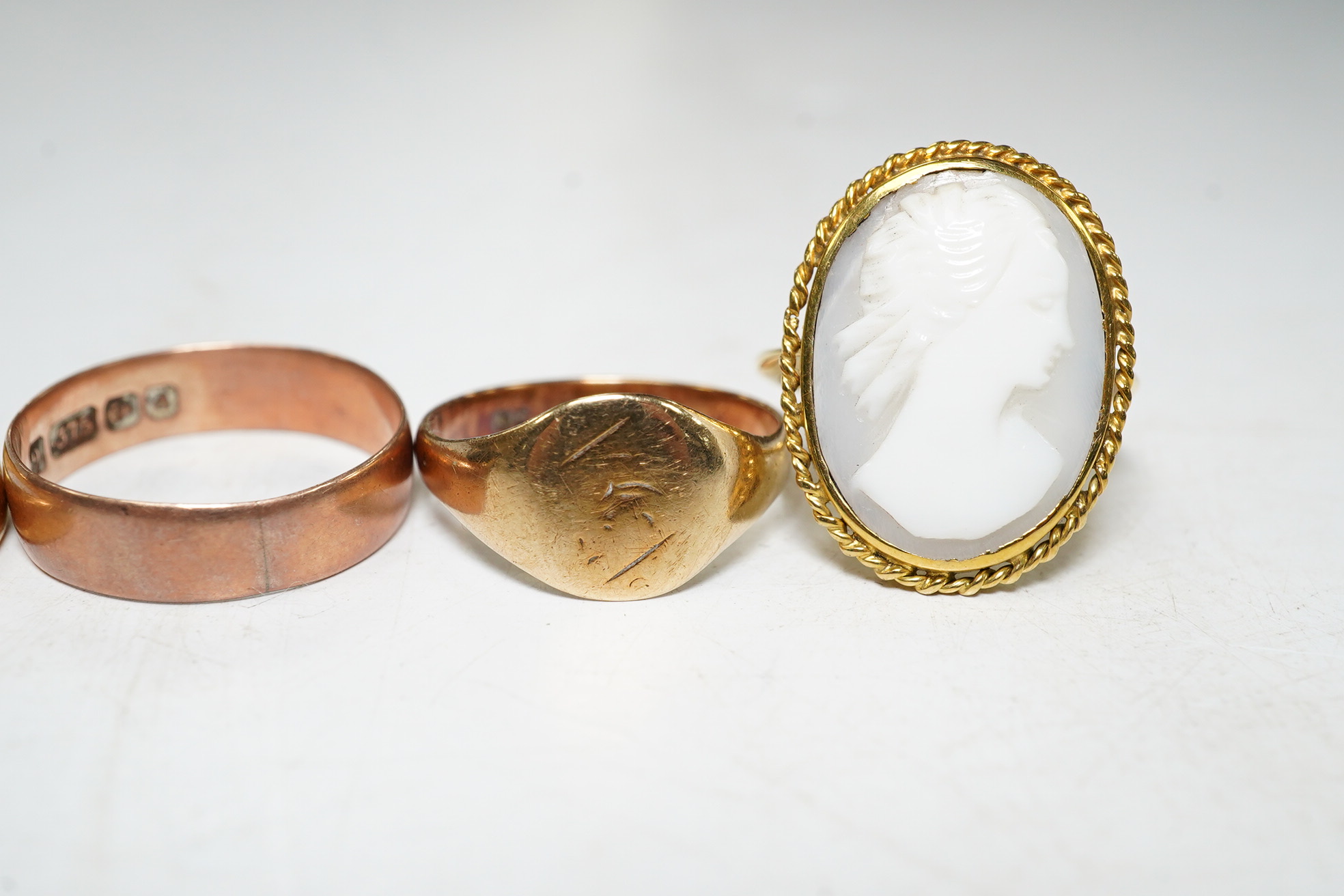 Five assorted rings: a 22ct gold band, size L, 4.2 grams, a 9ct rose gold band, size O, 2.1 grams, a 9ct gold signet ring, size M, 2.1 grams, a red cabochon set yellow metal ring, size I, gross 1.4 grams and a cameo set